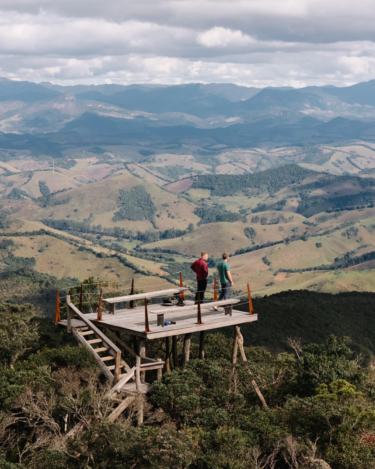 Morros de pastagem e fragmentos de mata vistos do mirante, até o horizonte da serra