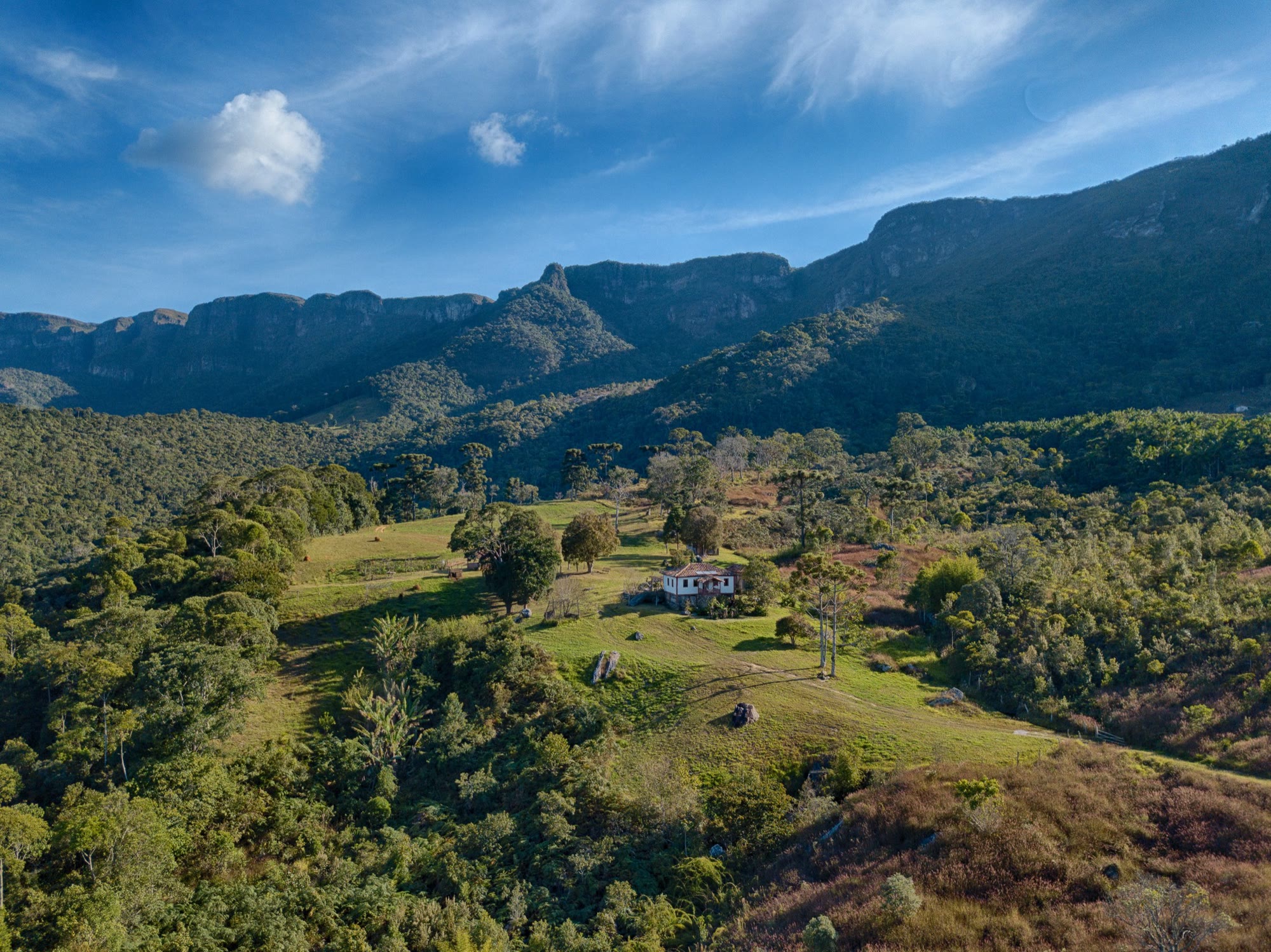 Vista aérea do Areião: encostas de Mata Atlântica e paredões rochosos na Mantiqueira