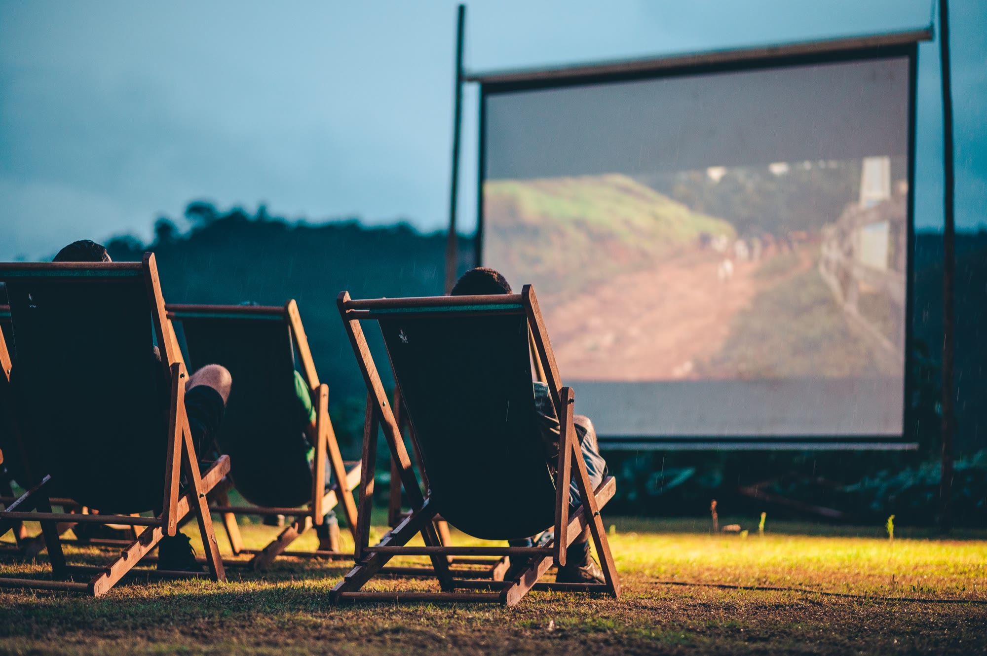 Cinema ao ar livre: espreguiçadeiras diante da tela ao anoitecer